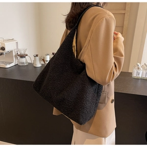 Détail du sac fourre-tout noir en peluche montrant la texture douce et la bandoulière fine