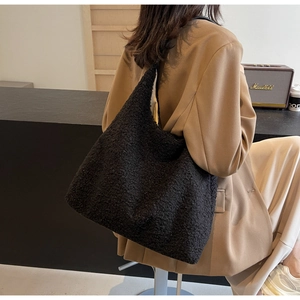 Détail du cabas en polaire noire montrant la texture pelucheuse d'un sac à bandoulière