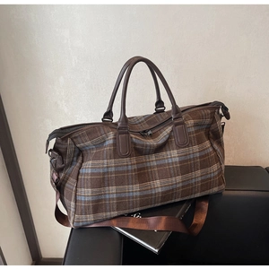 Vue détaillée du grand sac de voyage à carreaux avec poignées marron et bandoulière réglable