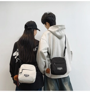 Détail de sacs bandoulière en toile avec logo de marque et pendentif ours mignon