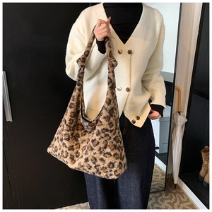 Close-up of leopard print suede tote bag with textured faux fur and knotted handle detail