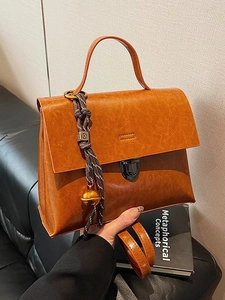Sac à main vintage caramel en cuir ciré avec rabat et pendentif tissé élégant