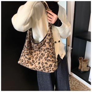 Lifestyle shot of large leopard print plush tote bag worn over the shoulder for winter