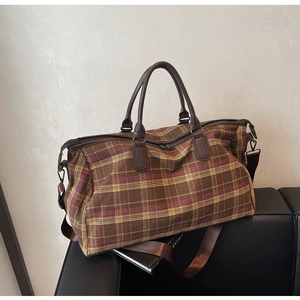 Détails du sac de voyage à carreaux avec poignées en cuir et fermetures métalliques