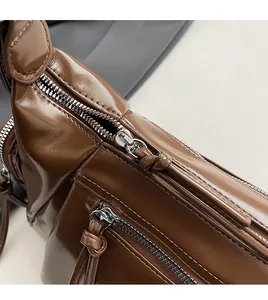 Détails des fermetures éclair et des coutures sur un sac à bandoulière vintage en cuir brun