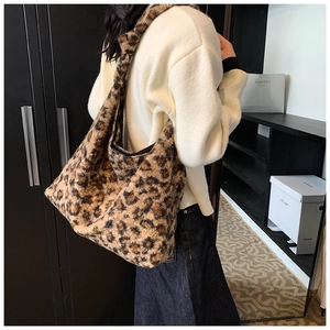 Detailed view of the soft faux fur leopard print tote bag worn on a model's shoulder