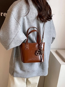 Sac seau en cuir marron minimaliste avec poignée et bandoulière élégante pour femme