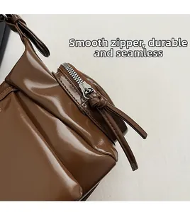 Détail de la fermeture éclair fluide et du cuir synthétique du sac polochon marron