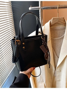 Sac seau noir chic avec finition brillante, ferrures dorées et un pendentif mini boulier
