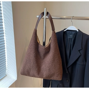 Details einer dunkelbraunen Teddy-Plüsch-Tote Bag mit hochwertigen Leder-Schultergurten