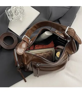 Vue de dessus de l'intérieur spacieux d'un sac porté épaule marron avec accessoires