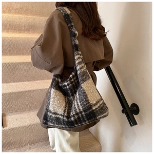 Close-up of the thick plaid texture and soft fabric of this oversized winter hobo tote bag