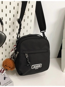 Sac bandoulière en nylon noir minimaliste avec fermeture éclair et peluche chien