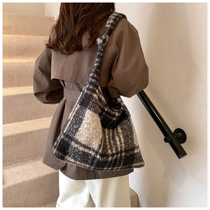 Detailed view of the black and white checkered plush tote with stylish knotted shoulder strap