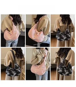 Crescent shaped tote bag featuring textured fabric and wide strap for casual wear