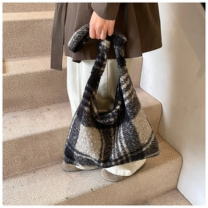 Detail of grey plaid knit tote bag featuring a creative knotted handle and soft texture