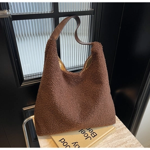 Détail du sac fourre-tout en peluche marron foncé avec texture laine d'agneau et anses cuir