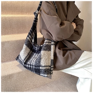 Close-up of large black and white checkered tote bag in soft plush wool material