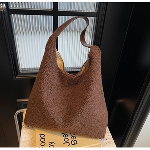 Détail du grand sac cabas en peluche marron montrant la texture douce et la bandoulière