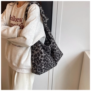 Detail of plush faux fur leopard print tote bag texture and wide shoulder strap design
