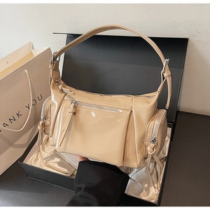 Sac en cuir verni beige brillant avec fermetures éclair argentées dans un coffret