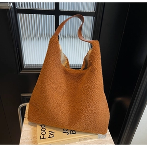 Gros plan du sac cabas caramel en polaire avec texture laine d'agneau et anse en cuir