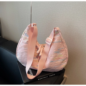 Close-up of pink tote bag with colorful wave embroidery and textured quilted fabric