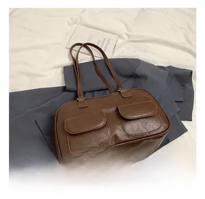 Macro shot of dark brown retro tote bag featuring double front pockets and leather texture