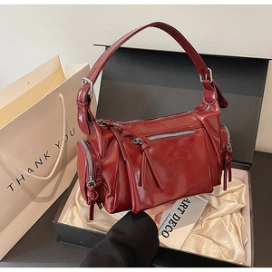 Sac en cuir rouge foncé brillant avec fermetures éclair argentées en coffret
