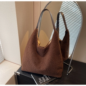 Gros plan du sac cabas en peluche marron foncé montrant la texture et l'anse