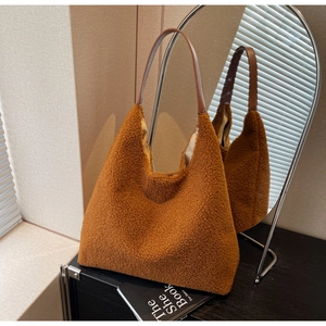 Gros plan du sac fourre-tout en peluche marron avec sa bandoulière en cuir
