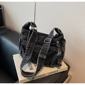 Detail view of black washed denim tote bag featuring multiple cargo pockets and silver hardware