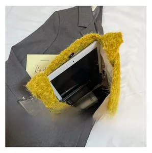 Detail view of large internal capacity of yellow plush tote bag with daily essentials