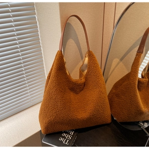 Détail d'un sac cabas en peluche marron avec texture sherpa et bandoulière en cuir