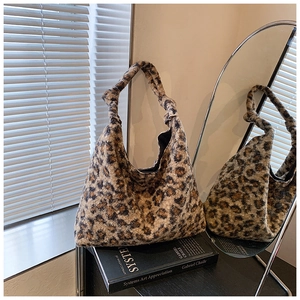 Detail view of the knotted shoulder strap and plush leopard print hobo bag texture