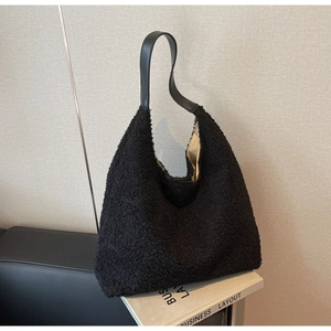 Détail du sac cabas en peluche noire montrant la texture douce et l'anse en cuir