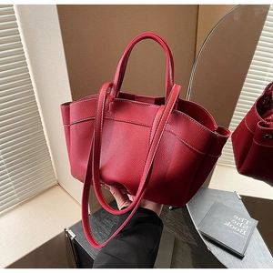 Detail of dark red lychee grain leather tote bag with sturdy handles and shoulder strap