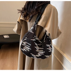 Detail of black fabric tote bag with colorful heartbeat line embroidery and wide strap
