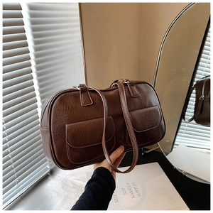 Detail of dark brown leather handbag with double front pockets and vintage pebble texture