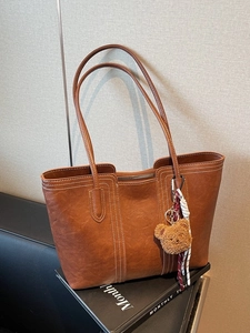 Brown large faux leather tote bag with contrast stitching and teddy bear charm