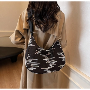 Detail of black crescent tote bag with wave embroidery and adjustable nylon strap