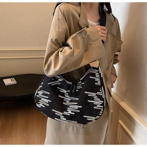Detail of black tote bag with pink and white embroidered heartwave pattern and wide strap