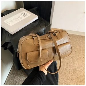 Close-up of retro brown textured leather shoulder bag with double front pockets and silver hardware
