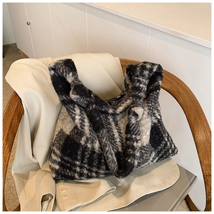 Detail shot of large checkered plush tote bag with fuzzy texture on a beige blazer