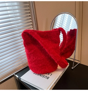 Detail of red plush faux fur texture and bucket bag design in cozy indoor setting
