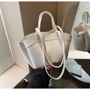 Detail of cream tote bag with lychee grain leather texture and double strap design