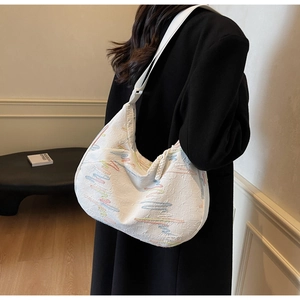 Detail view of large white tote bag with colorful textured pattern on a female model