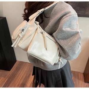 Vue détaillée d'un sac bandoulière beige à poches multiples avec bandoulière réglable