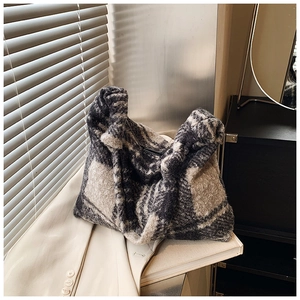 Detail of tweed tote bag showing soft texture and classic black white plaid pattern