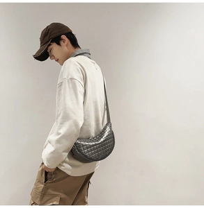 Detail der metallgrauen Mondsichel-Tasche mit Steppmuster am Modell getragen